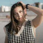 A woman with her hair in a houndstooth sweater