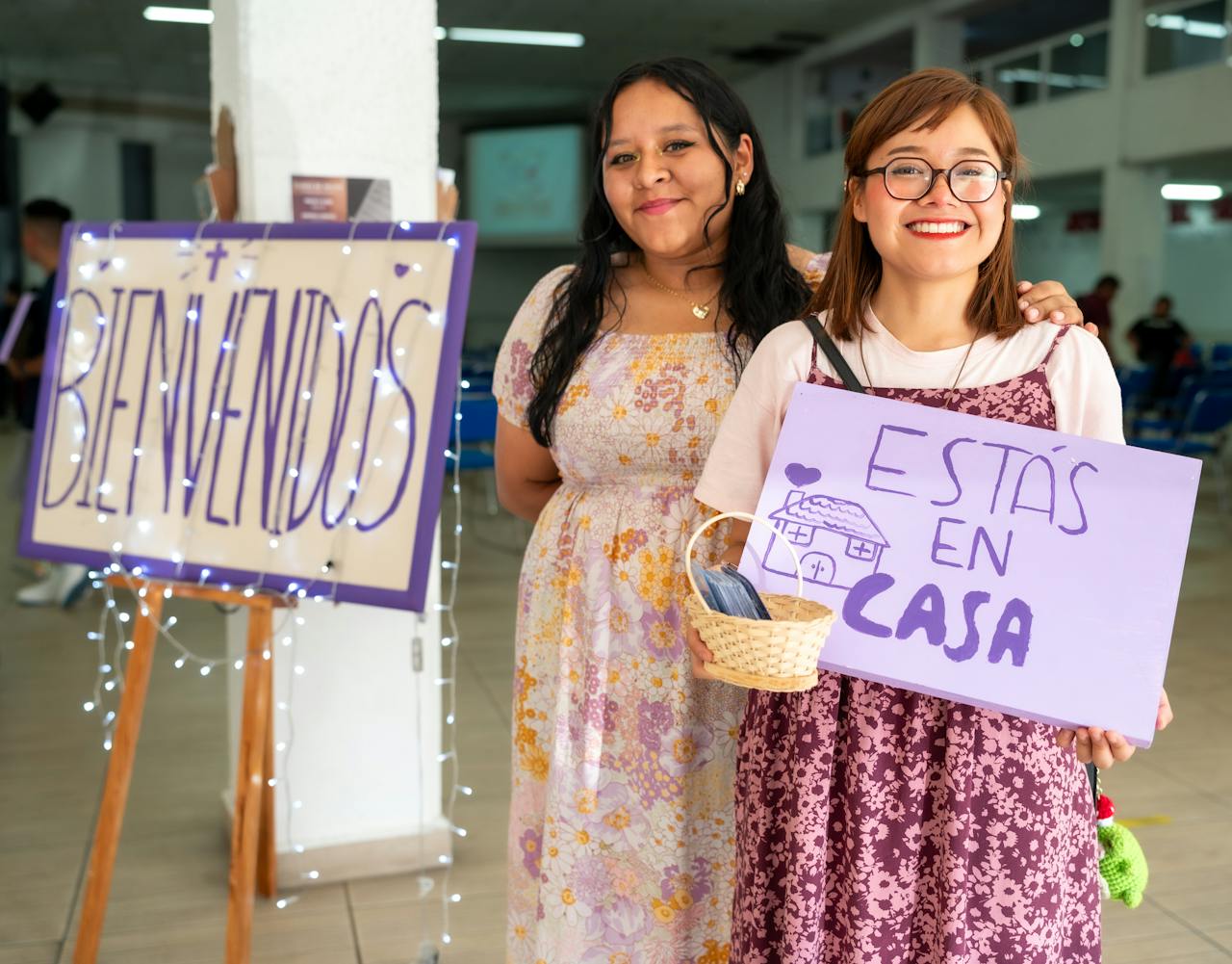 Two women holding signs that say esas and casa