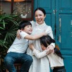 Photo of Woman Hugging Her Children While Smiling